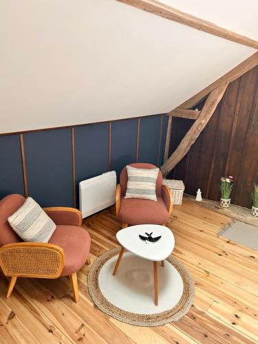 a living room with two chairs and a table at La Grange Aux Hirondelles - Chambre familiale in Woignarue