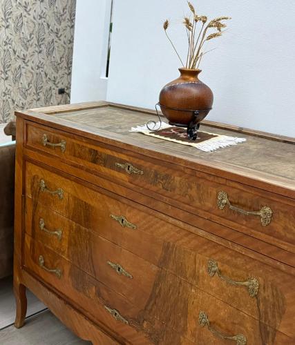 a vase sitting on top of a wooden dresser at An apartment with fireplace in Tirana