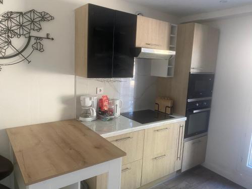 une cuisine avec des armoires en bois et un comptoir dans l'établissement Les Pommiers, à Argenteuil