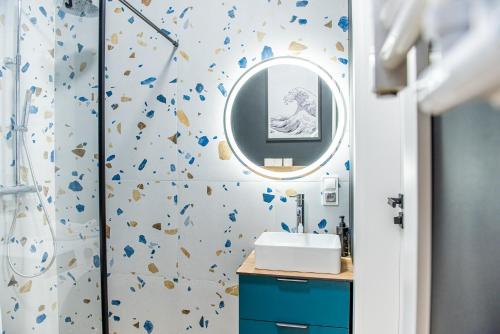 a bathroom with a blue sink and a mirror at Apartament w City Park nad jeziorem in Szczecinek