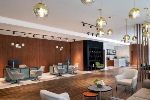 a lobby with chairs and tables and a wine cellar at Marriott Executive Apartments Doha, Le Mirage City Walk in Doha
