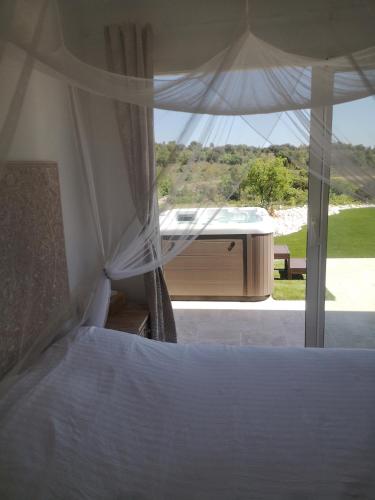 - une chambre avec un lit et une vue sur une baignoire dans l'établissement Invitation au voyage, à Les Mages