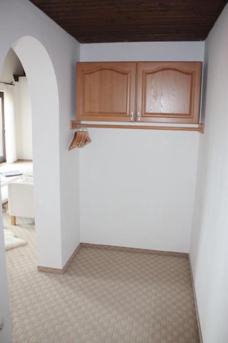 a kitchen with white walls and wooden cabinets at Landhotel Maiergschwendt inkl Chiemgaukarte in Ruhpolding