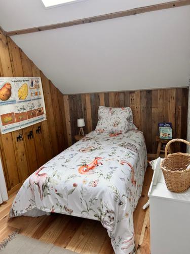 a bed in a room with wooden walls at La Grange Aux Hirondelles - Chambre familiale in Woignarue