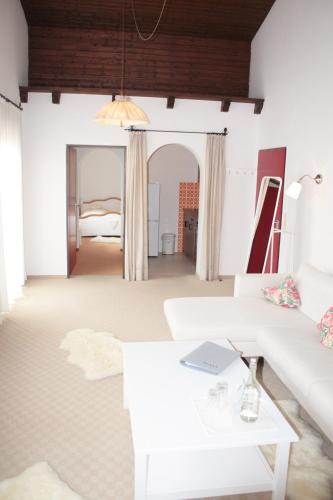 a living room with a white couch and a table at Landhotel Maiergschwendt inkl Chiemgaukarte in Ruhpolding