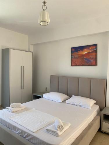 a bedroom with a bed with two towels on it at Hotel Mesun Himare in Himare