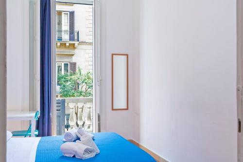 a bedroom with a blue bed and a window at A Casa di Amici in Palermo