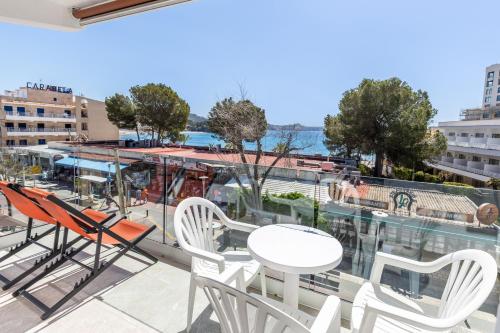 a balcony with chairs and a table and a view of the water at Hostal Neptuno in Paguera