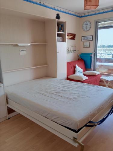 un grand lit dans une chambre avec une fenêtre dans l'établissement Au Bord de Mer, à Saint-Malo