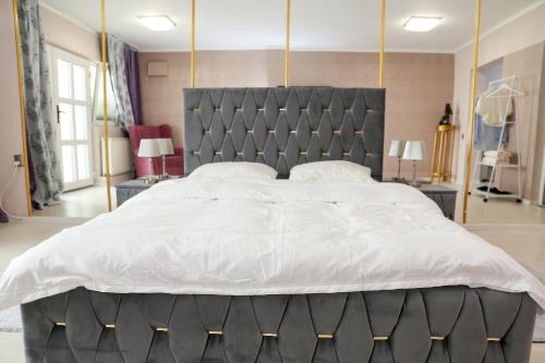 a bedroom with a large bed with a gray headboard at Azur House in Cluj-Napoca