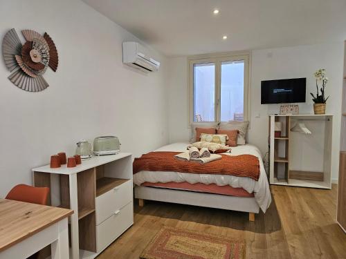 une chambre avec un lit, un bureau et une télévision dans l'établissement Les Résidences de Collioure, à Collioure