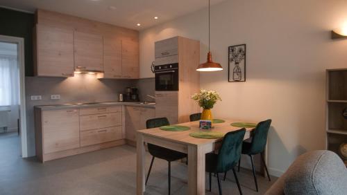 a kitchen with a wooden table and chairs in a room at Vakantiehuisjes "De Veldzijde" in Losser