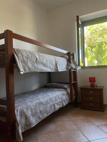 two bunk beds in a room with a window at La Casa Sul Lago in Bortigiadas
