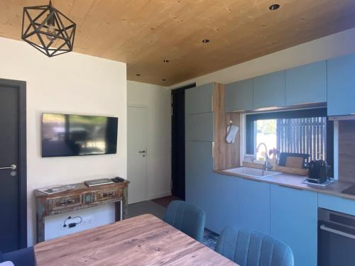 a kitchen with a wooden table and blue chairs at L'Appart-MoH Yvoire in Yvoire