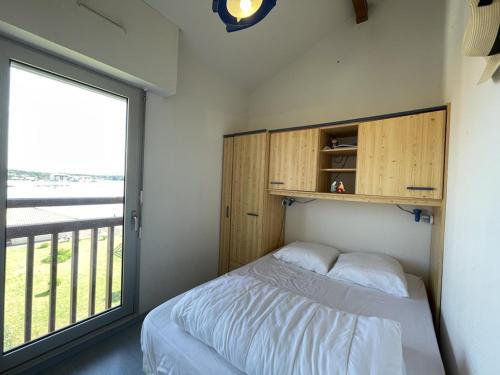 a bedroom with a bed and a large window at T2 avec Mezzanine, Piscine, Parking, Animaux admis - FR-1-379-131 in Vieux-Boucau-les-Bains