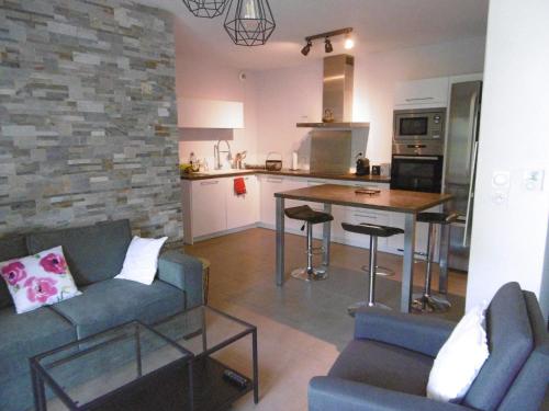un salon avec un canapé et une cuisine dans l'établissement Séjour à Sète : Bel Appartement 3 Pièces avec Loggia, Proche Plage et Commerces - FR-1-472-153, à Sète