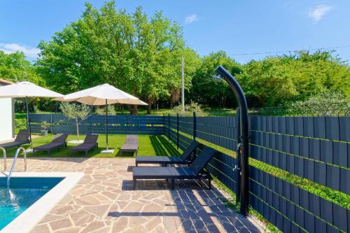 a blue fence with benches next to a swimming pool at Holiday Home Petar by Rent Istria in Buje