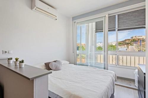 ein Schlafzimmer mit einem Bett und einem großen Fenster in der Unterkunft Cala de Mijas Beach & Golf Studio in La Cala de Mijas