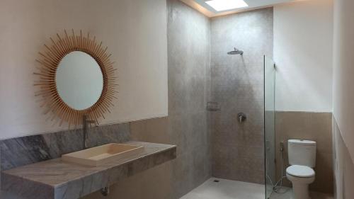 a bathroom with a sink and a mirror and a toilet at HiKina - Best Value Private Pool Villa in Canggu