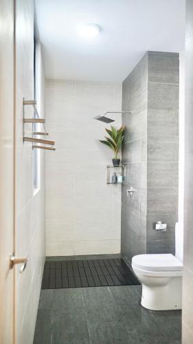 a bathroom with a toilet and a potted plant at Troika Kota Bharu by Larissa Stay in Kota Bharu