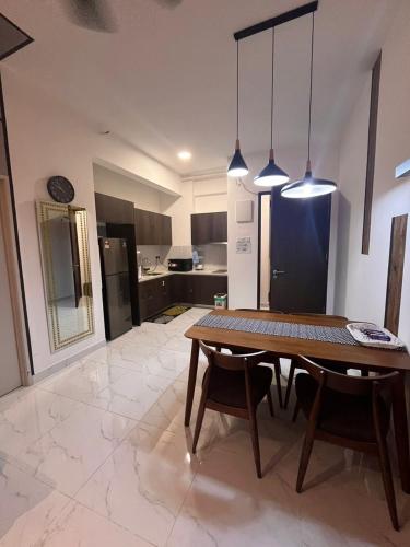a living room with a table and a kitchen at Troika Kota Bharu by Larissa Stay in Kota Bharu