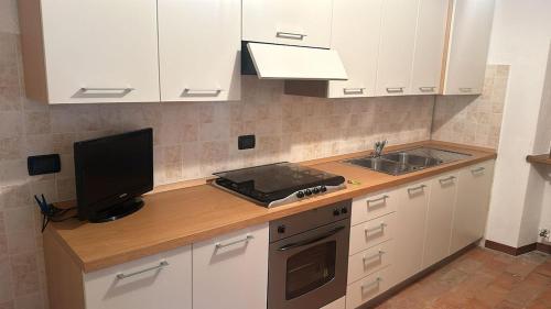 a kitchen with a counter with a television and a sink at Da Antonio in Roccaprebalza