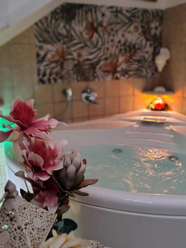 a bathroom with a bath tub with flowers in it at Lyssa Holiday Apartments in Taormina