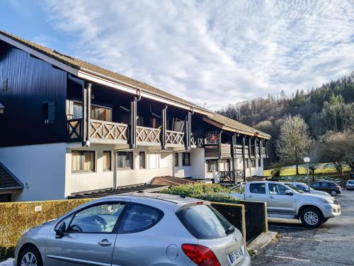 un bâtiment avec des voitures garées dans un parking dans l'établissement Y'Hôtes - Studio Evasion près des pistes, à Saint-Jeoire