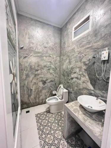 a bathroom with a toilet and a sink at TheHill Resort เลาขวัญ in Ban Nong Masang