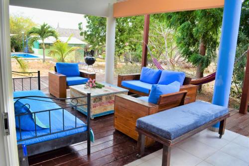 a porch with a hammock and chairs and a table at Don Genaro Apartments in Barber