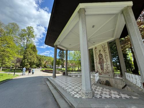 a pavilion with people walking in a park at Penzion Zornicka in Bardejovské Kúpele