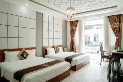a hotel room with two beds and a window at Lucasta Hotel in Can Tho
