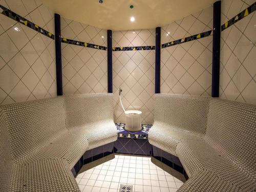 a tiled bathroom with a toilet in a room at Hotel Gasthof Lercher in Murau