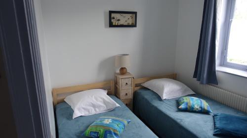 two twin beds in a room with a window at Gîte My Cottage Baie de Somme avec sauna in Cayeux-sur-Mer