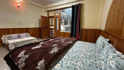 a bedroom with a bed and a window at Kashwika Stays Jibhi in Jibhi