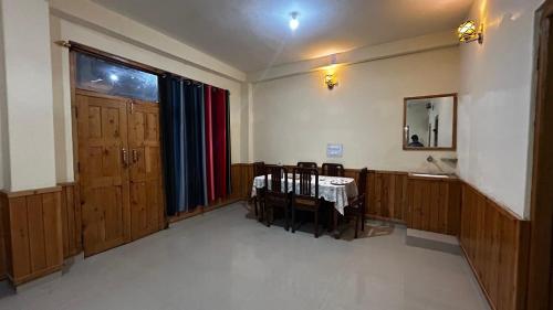 an empty room with a table and chairs in it at Kashwika Stays Jibhi in Jibhi