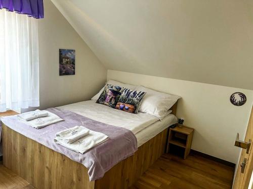 a bedroom with a bed with two towels on it at Lawendowa Willa in Kaczki Średnie