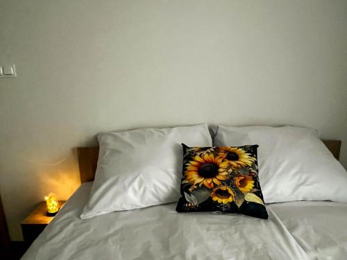 a pillow on a bed with two pillows at Lawendowa Willa in Kaczki Średnie