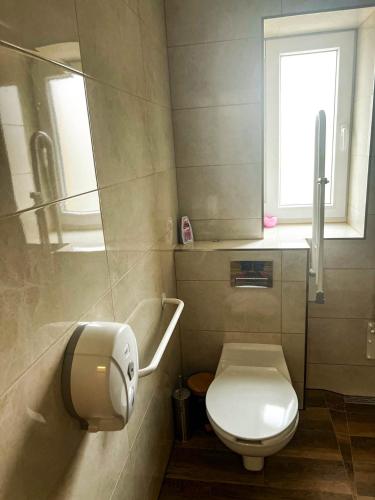 a small bathroom with a toilet and a window at Lawendowa Willa in Kaczki Średnie