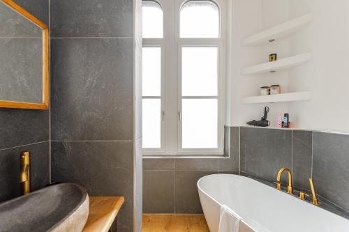 a bathroom with a white tub and a window at Wohnen wie im Schloss - Alter Bahnhof von Kruft in Kruft