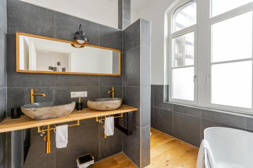 a bathroom with two sinks and a mirror at Wohnen wie im Schloss - Alter Bahnhof von Kruft in Kruft