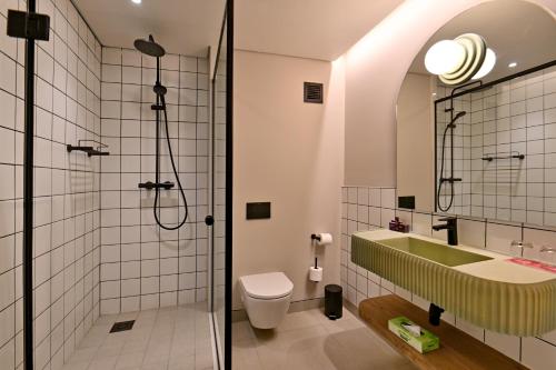 a bathroom with a shower and a toilet and a sink at City Lodge Hotel Umhlanga Ridge in Durban