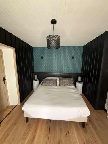a bedroom with a white bed and a blue wall at Maison vue Mer Ile de Ré - Rivedoux-Plage - Villa Raie Manta - Ile de Ré - 4 chambres - 2 salles d eau - 1 à 8 personnes - Plage à pied in Rivedoux-Plage
