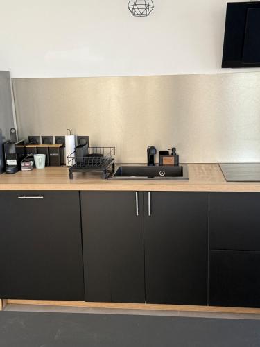 a kitchen with black cabinets and a counter top at Maison vue Mer Ile de Ré - Rivedoux-Plage - Villa Raie Manta - Ile de Ré - 4 chambres - 2 salles d eau - 1 à 8 personnes - Plage à pied in Rivedoux-Plage