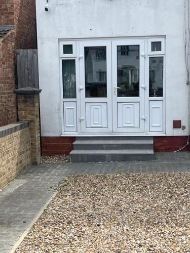 a white building with two doors on the side of it at Luxury Studio in Wembley in Wembley