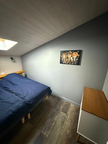 a bedroom with a blue bed and a table at Maison vue Mer Ile de Ré - Rivedoux-Plage - Villa Raie Manta - Ile de Ré - 4 chambres - 2 salles d eau - 1 à 8 personnes - Plage à pied in Rivedoux-Plage