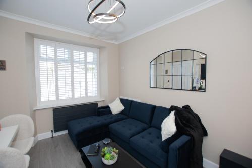 a living room with a blue couch and a mirror at The White House near Edinburgh in Bathgate