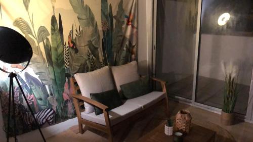 a living room with a chair and a mural at ღ Le Moana - Cocon climatisé au cœur de Montélimar in Montélimar