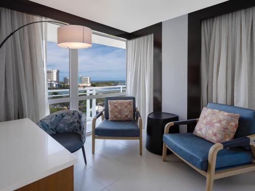 a hotel room with two chairs and a large window at Hilton Garden Inn San Juan Condado in San Juan