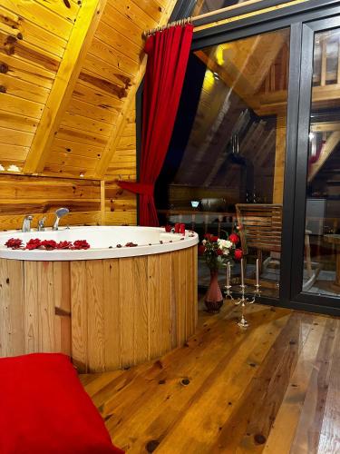 a bath tub in a room with a red curtain at Yamaçdere Bungalov in Ardeşen
